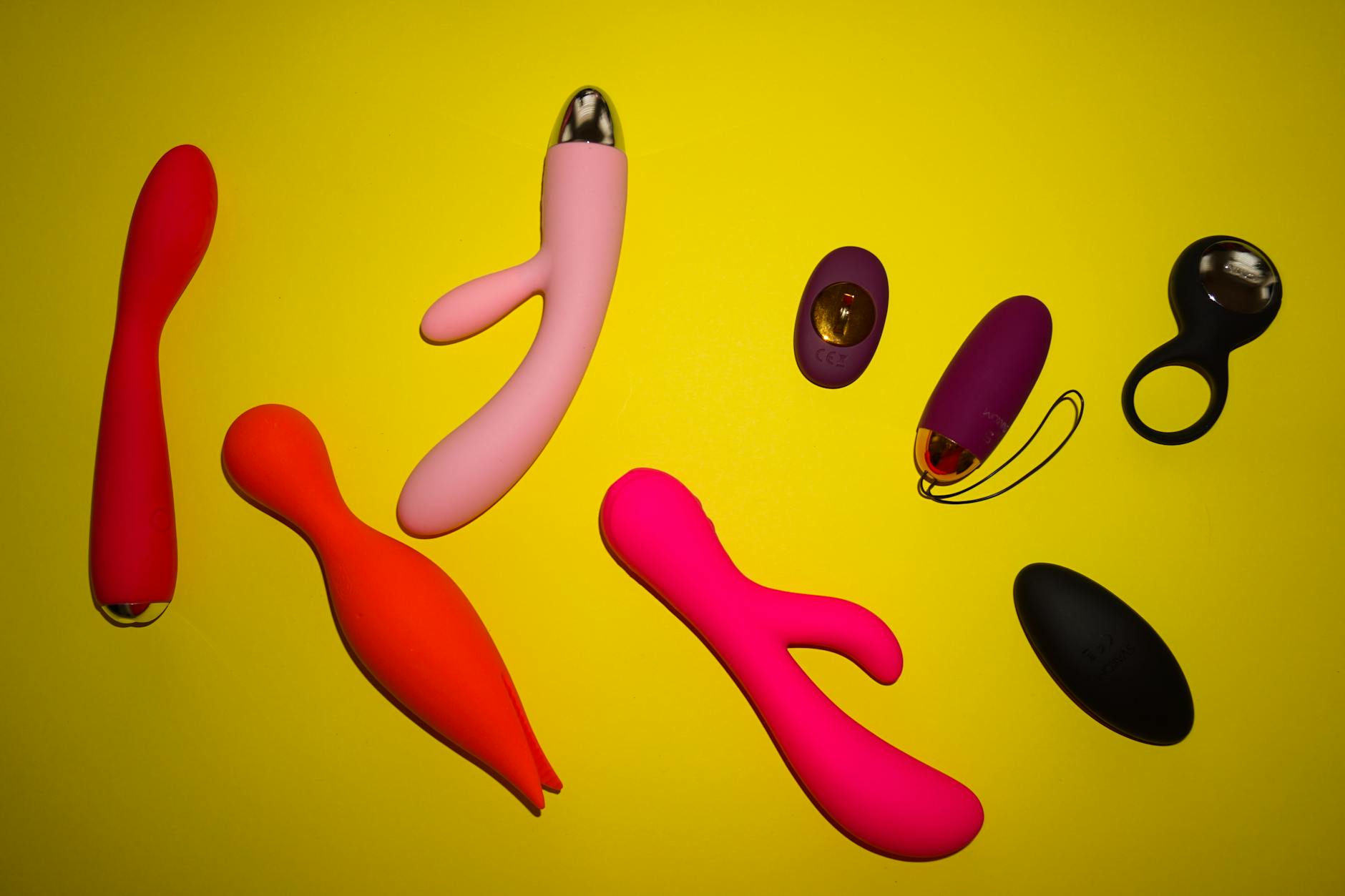 Vibrant collection of colorful lemon clitoral vibrators and toys arranged on a bright yellow background